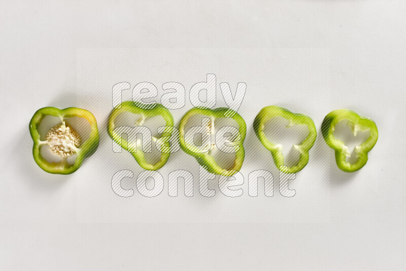Green bell pepper slices on white background