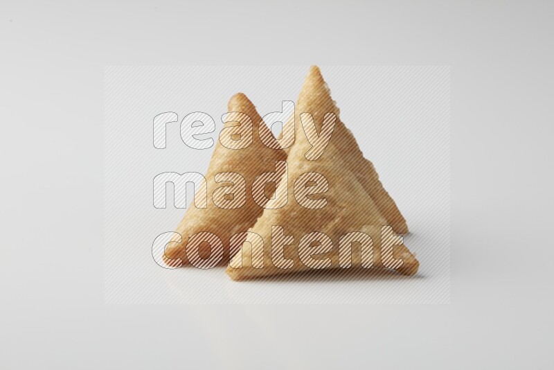 Three fried sambosas on a white background