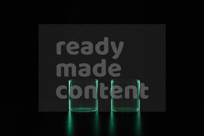 Glassware with rim light in green against black background