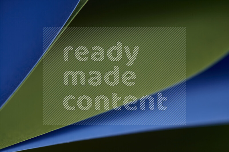 An abstract art showing blue and green paper sheets arranged in an overlapping curves