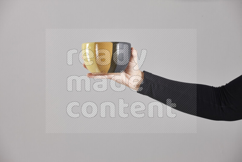 A woman in black abaya holding different pottery essentials in different positions