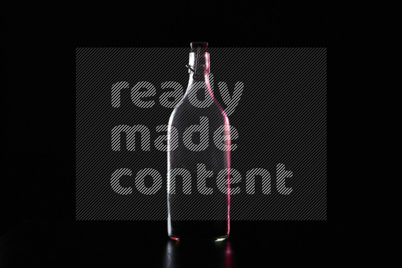 Water bottle with colored rim light against black background