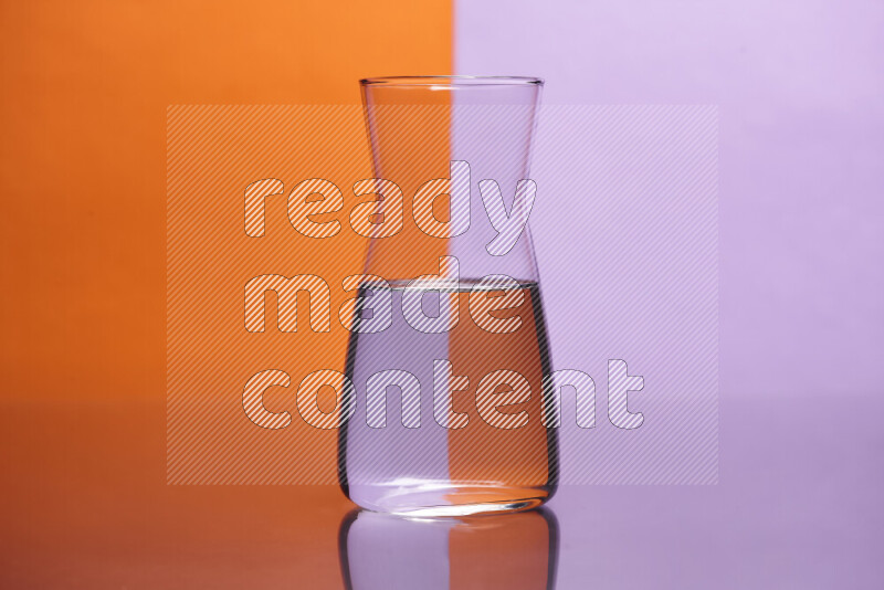 تظهر الصورة أواني زجاجية ممتلئة بالماء موضوعة على خلفية من اللونين البرتقالي والأرجواني الفاتح