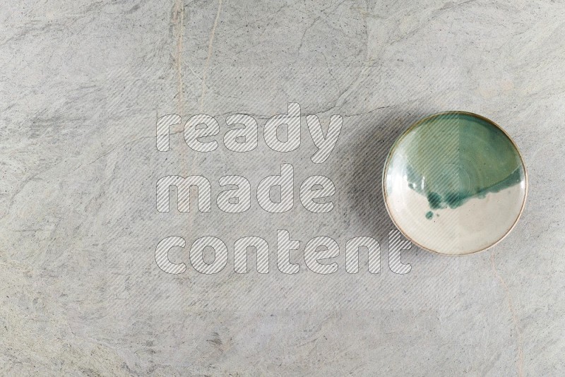 Top View Shot Of A Multicolored Pottery Bowl On Grey Marble Flooring