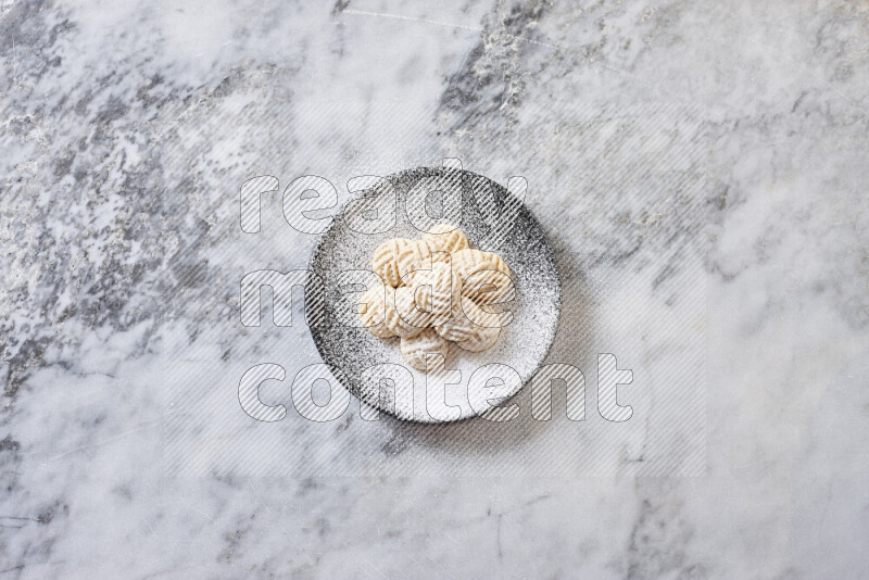Kahk in black pottery plate on grey marble background