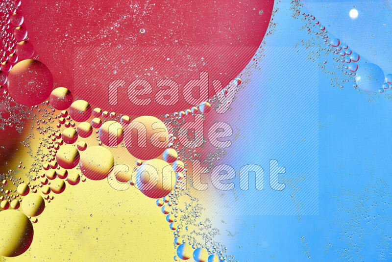 Close-ups of abstract oil bubbles on water surface in shades of yellow, red and blue