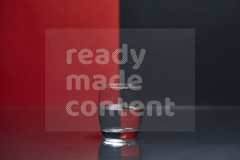 The image features a clear glassware filled with water, set against red and black background