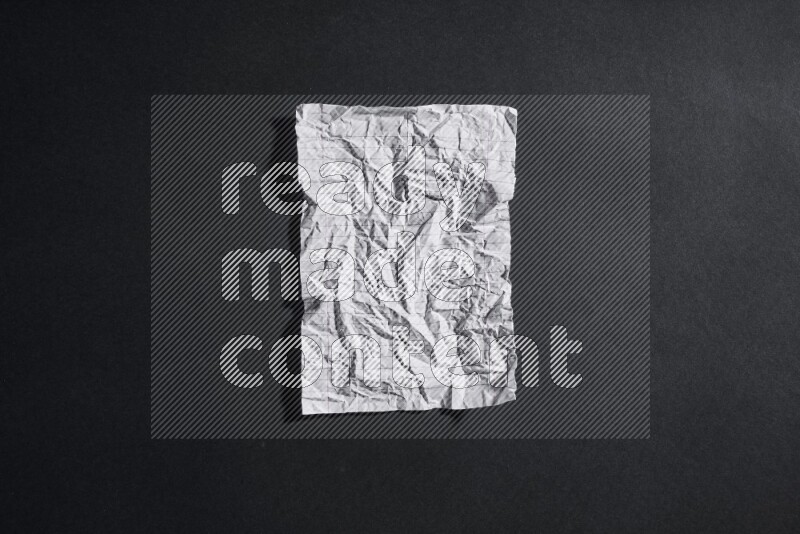 Crumpled notebook sheet on black background