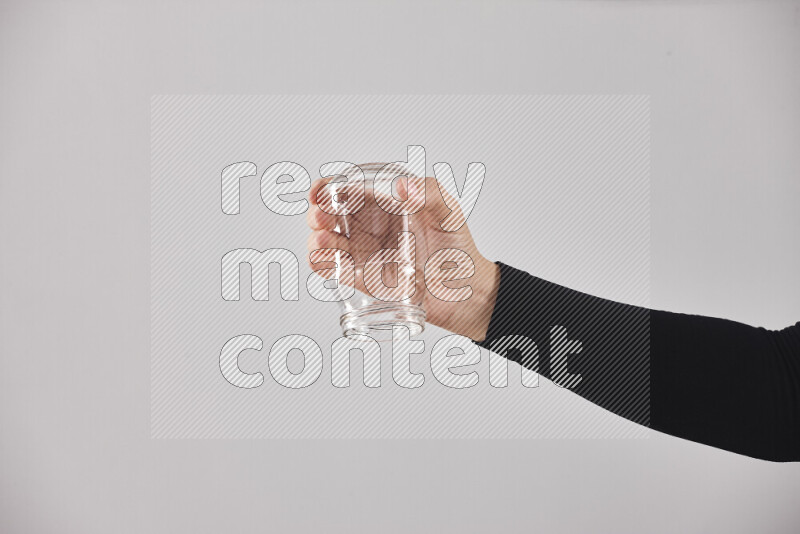 A woman in black abaya holding different glassware in different positions