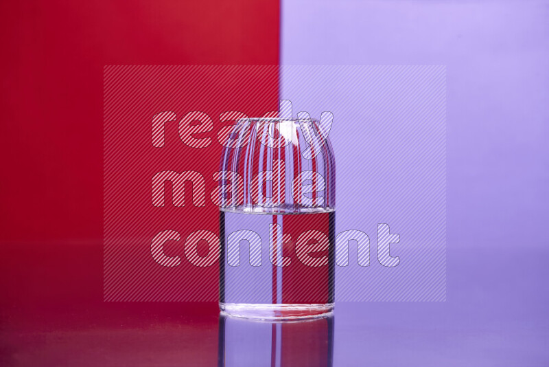 The image features a clear glassware filled with water, set against red and light purple background