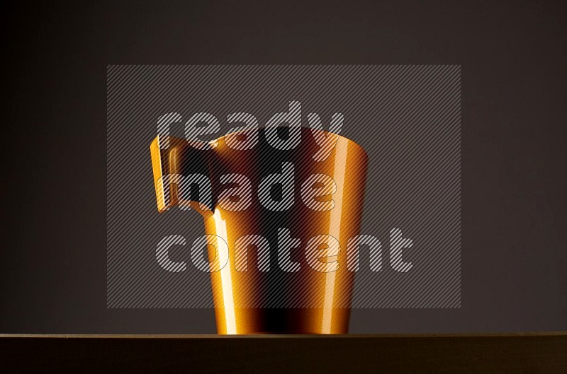 Low angle shot of a golden cup on grey background