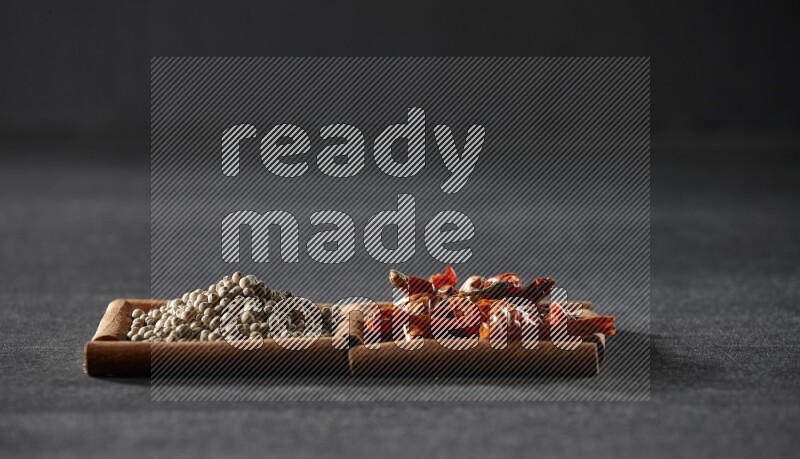 2 squares of cinnamon sticks full of chilis and white peppers on black flooring