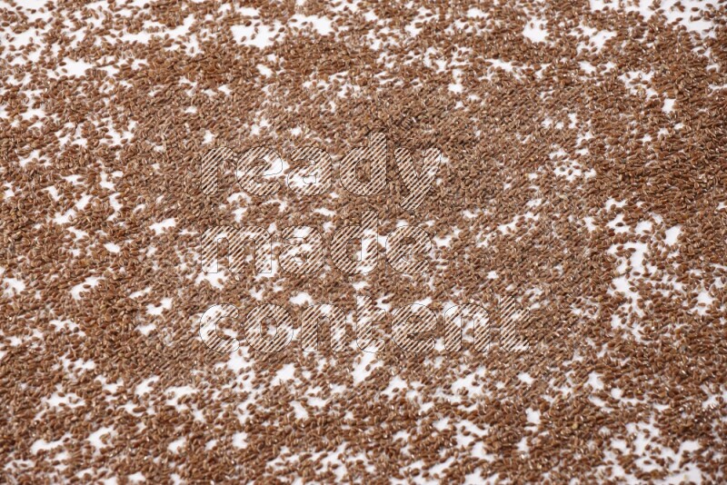 Flax seeds spread on a white flooring