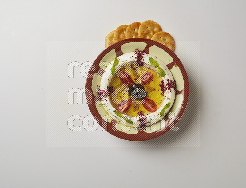 Lebnah garnished with Cherry tomato, mint & sumak  in a traditional plate on a white background