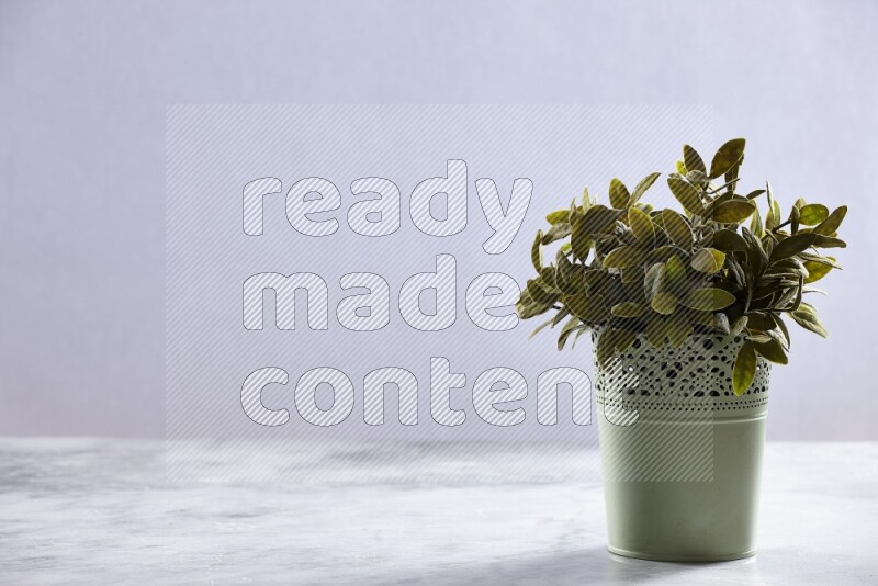Artificial plant in green decorative pot on grey marble background