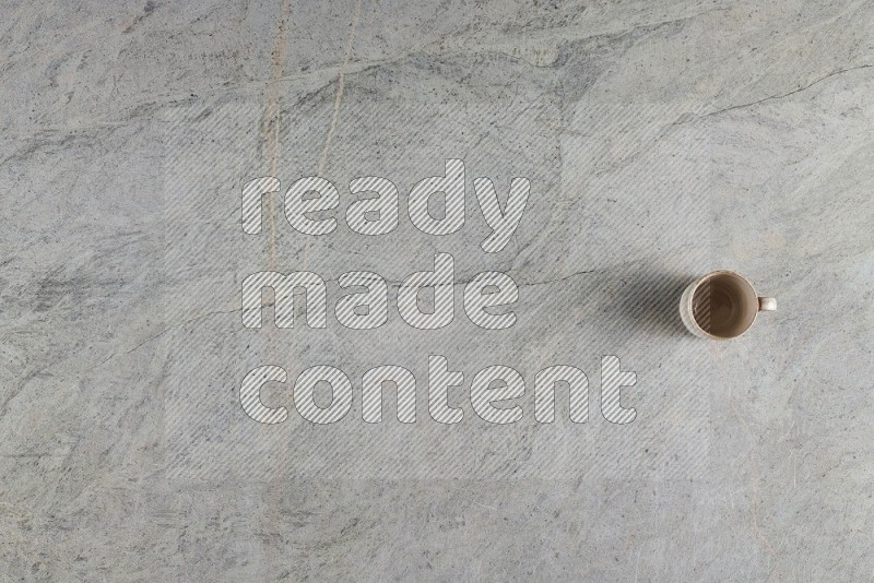 Top View Shot Of A Multicolored Pottery Cup On Grey Marble Flooring