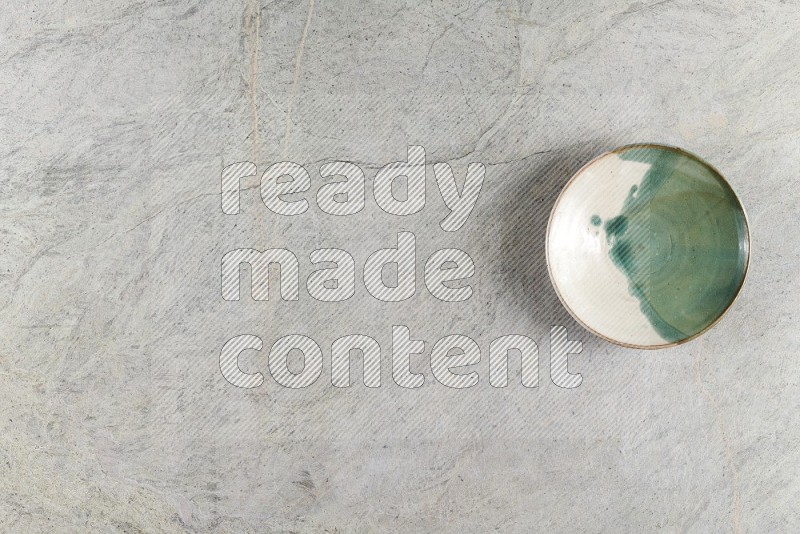 Top View Shot Of A Multicolored Pottery Bowl On Grey Marble Flooring