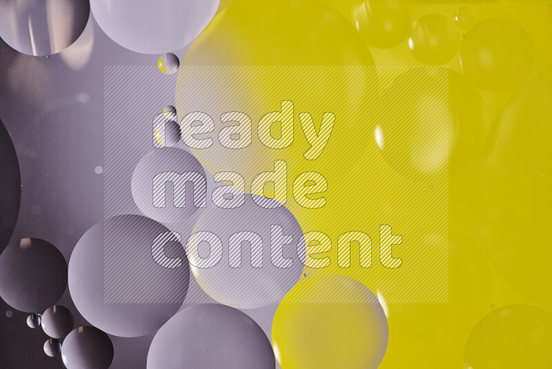 Close-ups of abstract oil bubbles on water surface in shades of black and yellow