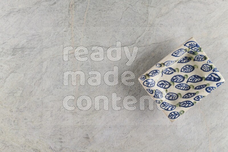 A decorative pottery plate on grey marble background