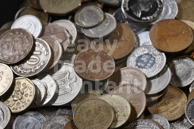 لقطات مقربة لعملات معدنية قديمة عشوائية على خلفية سوداء