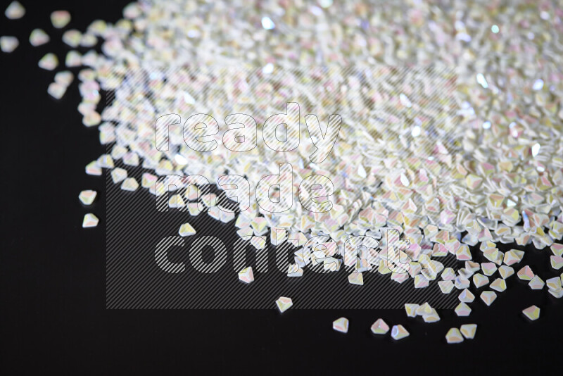 قطع صغيرة بلاستيكية ملونة للزينة متناثرة على خلفية سوداء