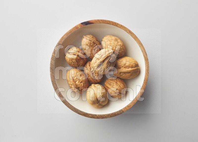 Top-view shot of walnut in a container on white background