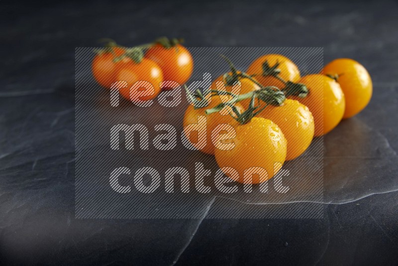 Mixed cherry tomato veins on a textured black slate background 45 degree
