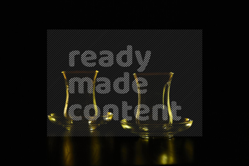 Glassware with rim light in yellow against black background