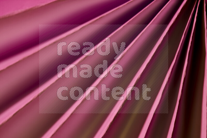An image presenting an abstract paper pattern of lines in pink and gold tones
