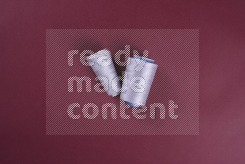 A grey collection of sewing and tailoring tools arranged on a red background