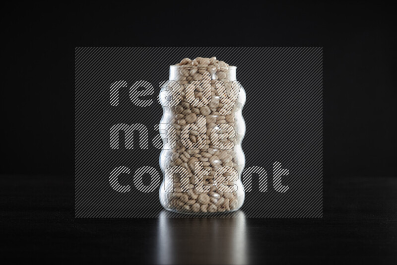 Lupin Beans in a glass jar on black background