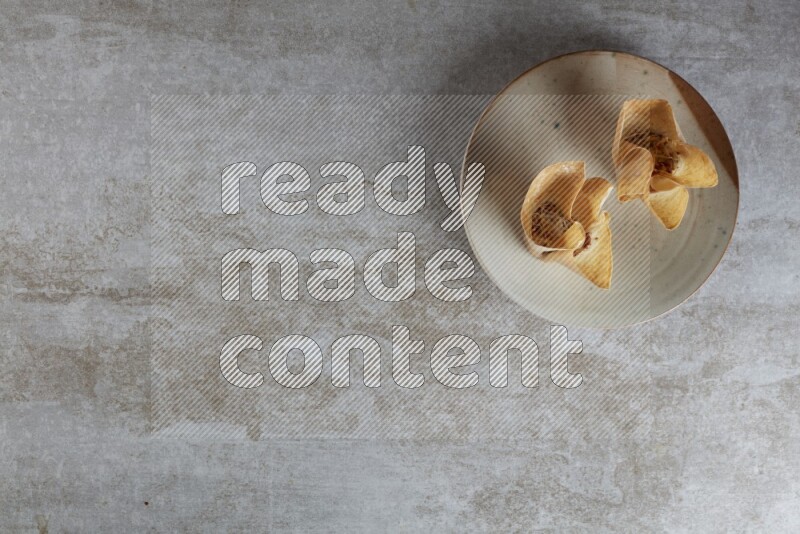 wonton cups with soy sauce ramkin on multi colored pottery on grey textured counter top