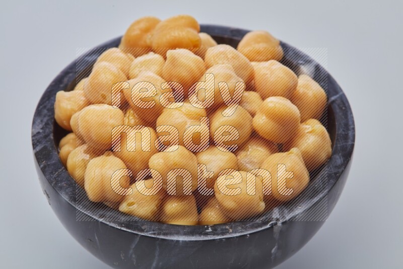 Close up of a boiled chickpeas in a container on white background