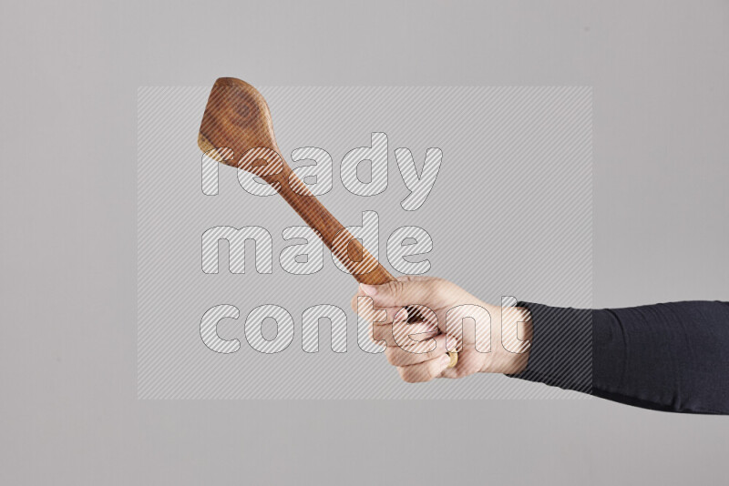 امرأة ترتدي عباءة سوداء تحمل أدوات خشبية مختلفة في أوضاع متعددة