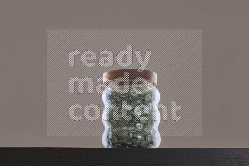 أزرار متنوعة في وعاء زجاجي علي خلفية سوداء