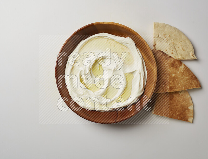 Lebnah garnished with olive oil in a wooden plate on a white background