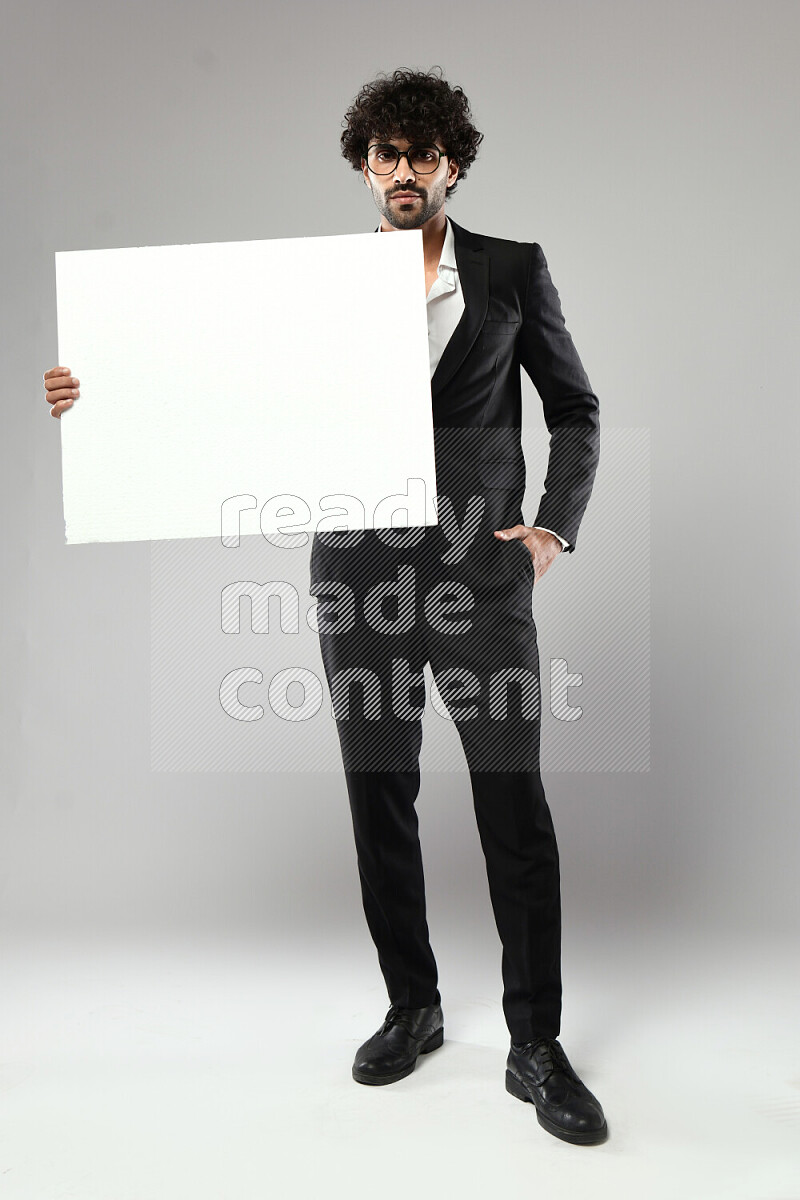 A man wearing formal standing and holding a white board on white background