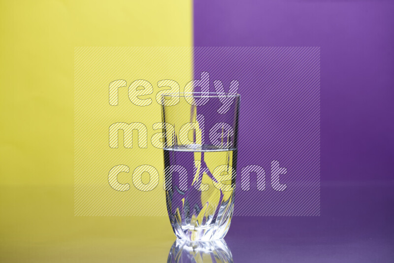 The image features a clear glassware filled with water, set against yellow and purple background