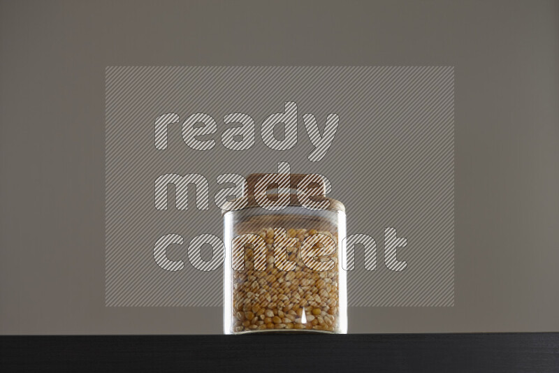 Pop corn in a glass jar on black background