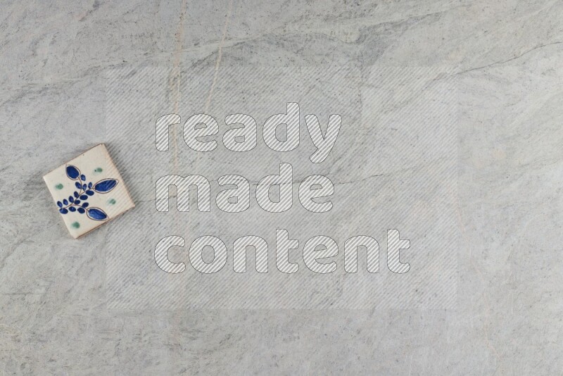 A decorative pottery coaster on grey marble background