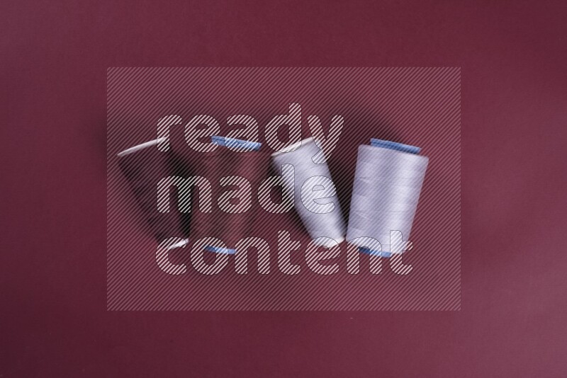 A grey collection of sewing and tailoring tools arranged on a red background