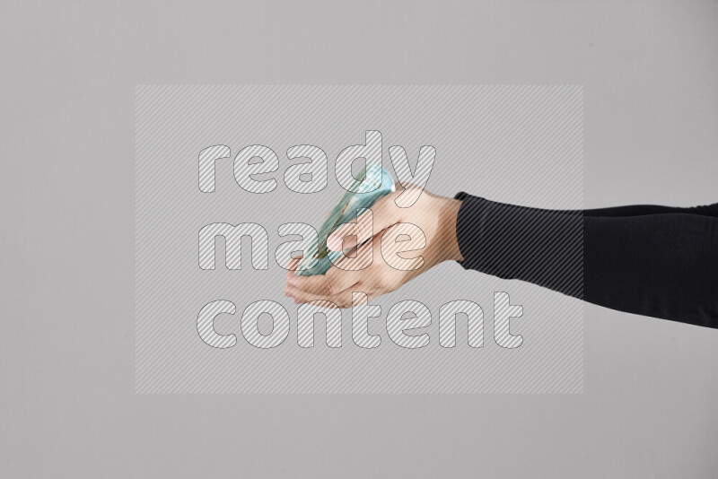 امرأة ترتدي عباءة سوداء تحمل أدوات فخارية مختلفة في أوضاع متعددة