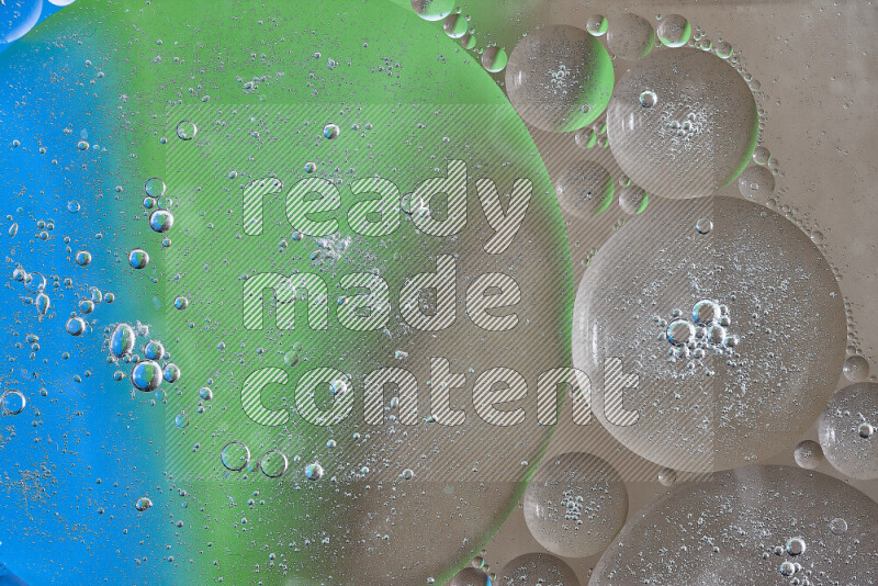 لقطات مقربة لفقاعات من الزيت على سطح الماء باللون البني والأخضر والأزرق