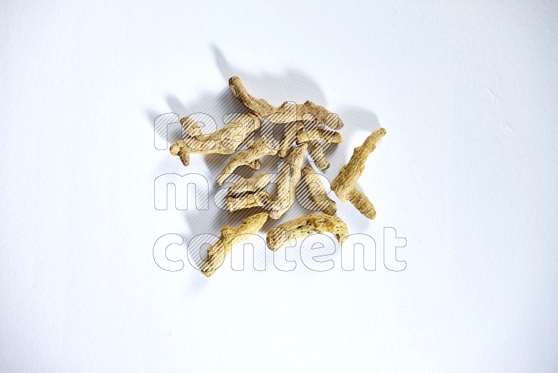 Dried turmeric whole fingers on white flooring