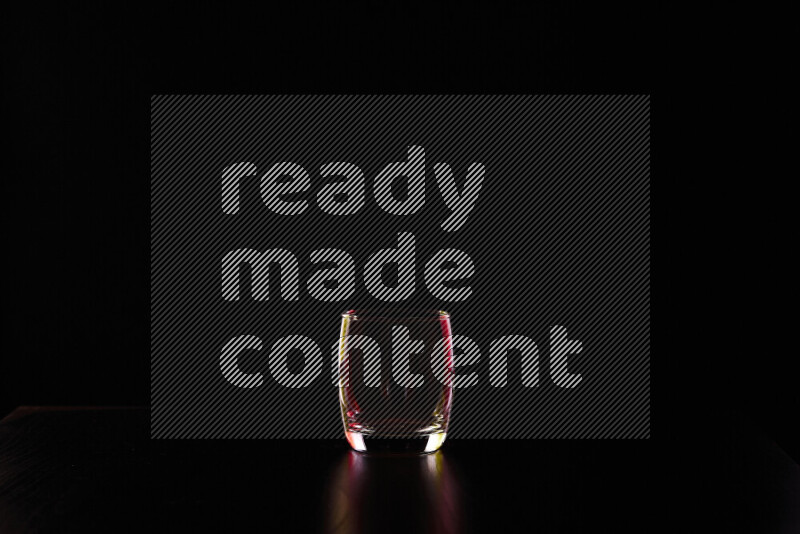 Glassware with rim light in red and yellow against black background