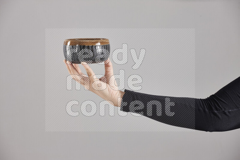 امرأة ترتدي عباءة سوداء تحمل أدوات فخارية مختلفة في أوضاع متعددة