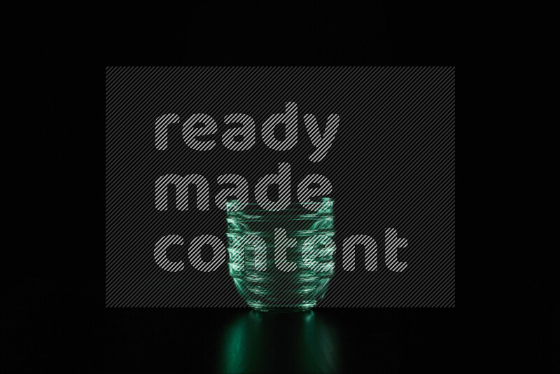 Glassware with rim light in green against black background