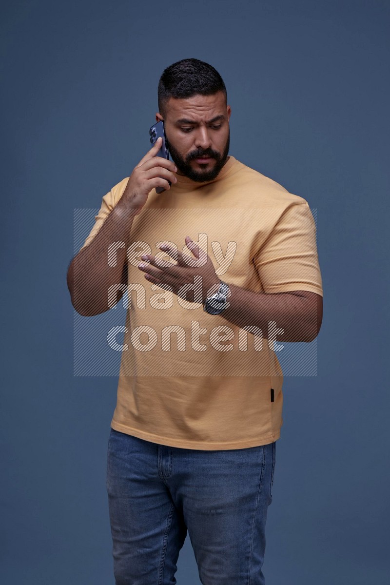 A man Calling on Blue Background wearing Orange T-shirt