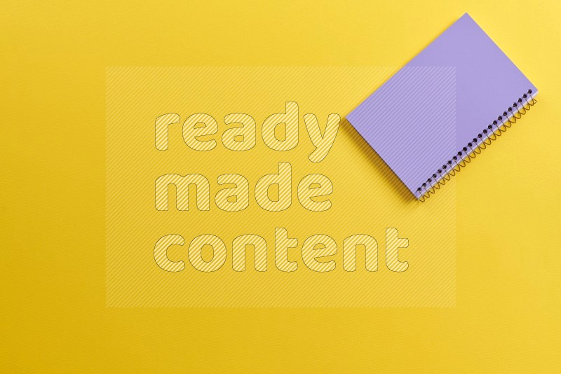 A purple notebook on yellow background (Back to school)