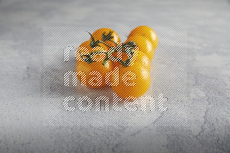 Yellow cherry tomato vein on a light grey textured background 45 degree